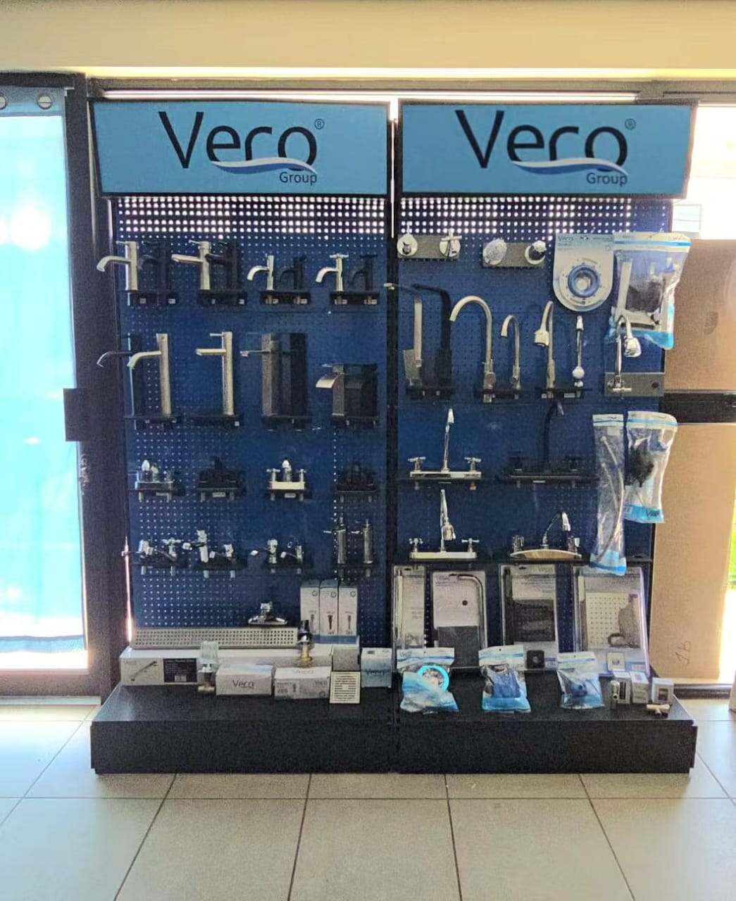 Exhibidor doble de marca VERO Group con grifería instalada en tienda de un distribuidor